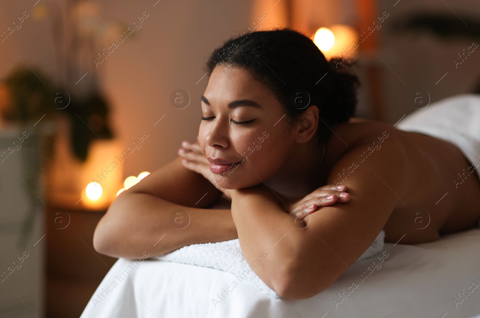 Photo of Beautiful woman relaxing on massage couch in spa salon