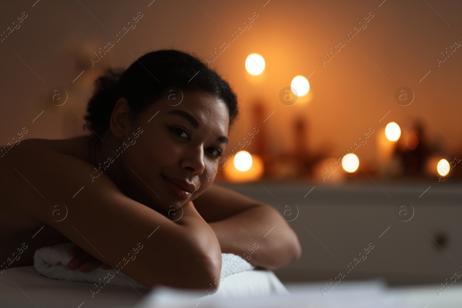 Photo of Beautiful woman relaxing on massage couch in spa salon, space for text