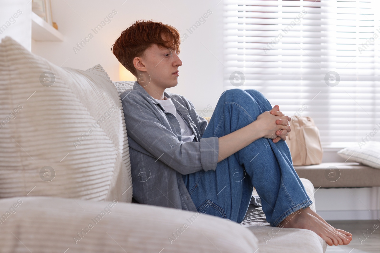 Teen problems. Depressed teenage boy on sofa at home Photo of Teen problems. Depressed teenage boy on sofa at home