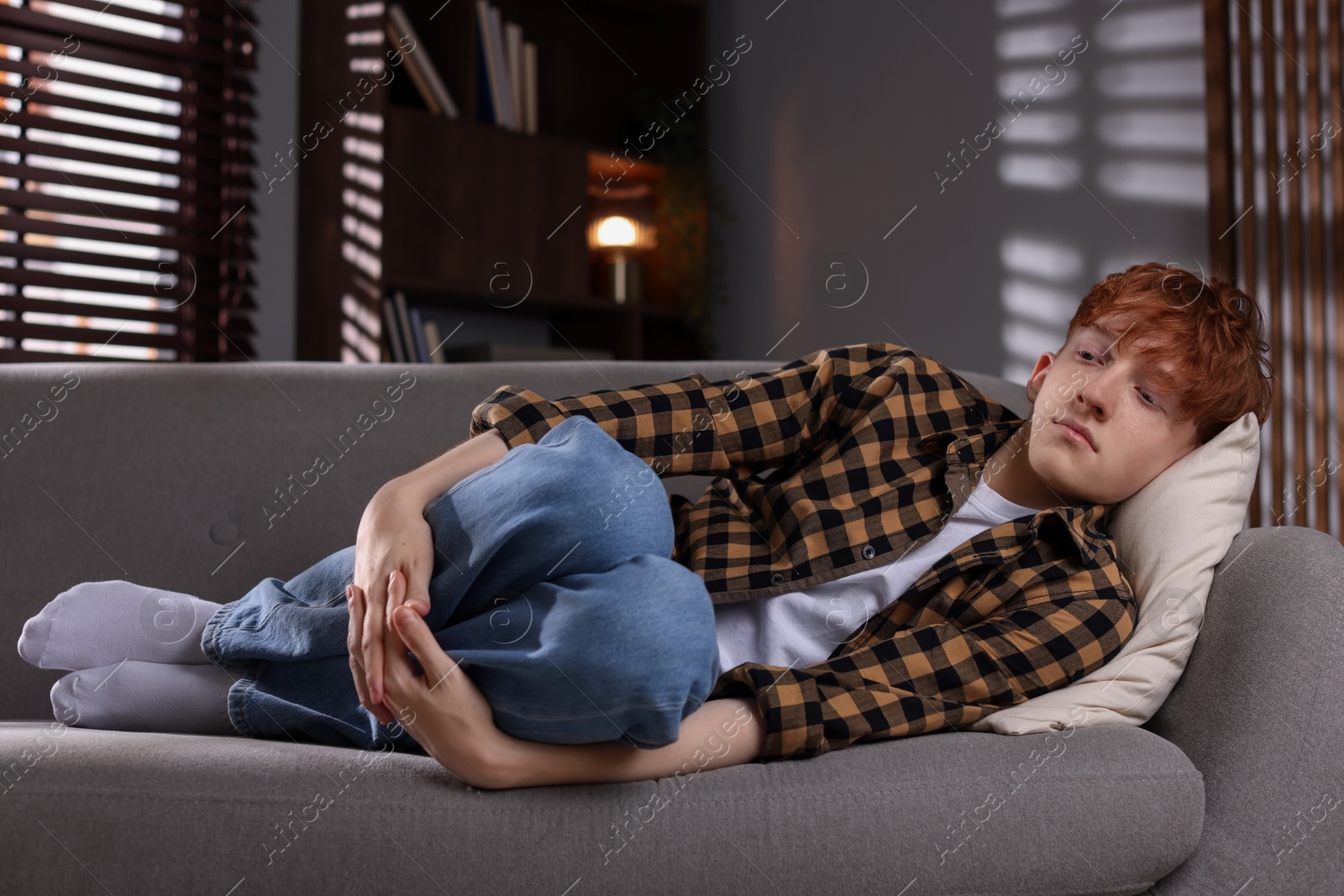 Teen problems. Depressed teenage boy lying on sofa at home Photo of Teen problems. Depressed teenage boy lying on sofa at home