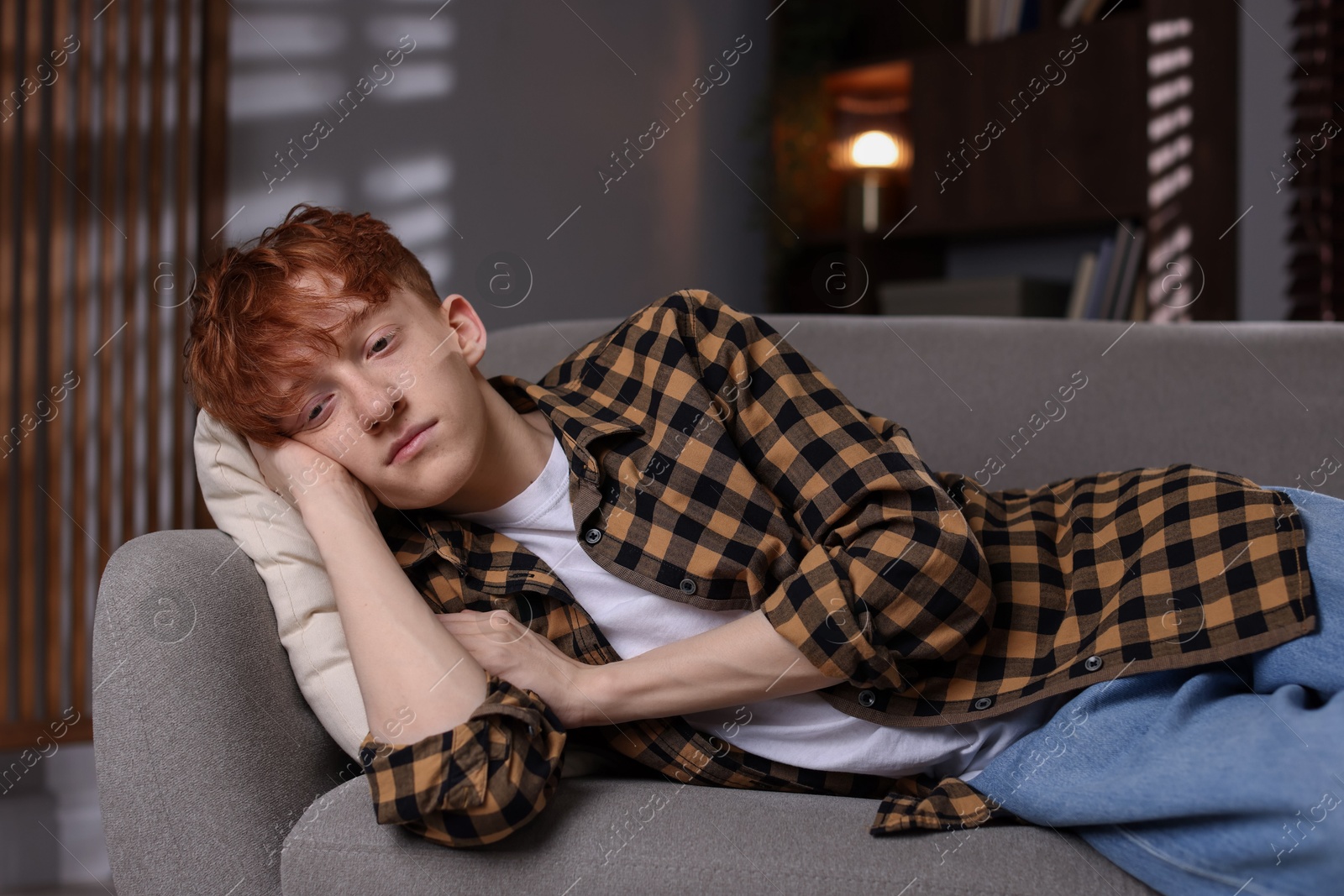 Teen problems. Depressed teenage boy lying on sofa at home Photo of Teen problems. Depressed teenage boy lying on sofa at home