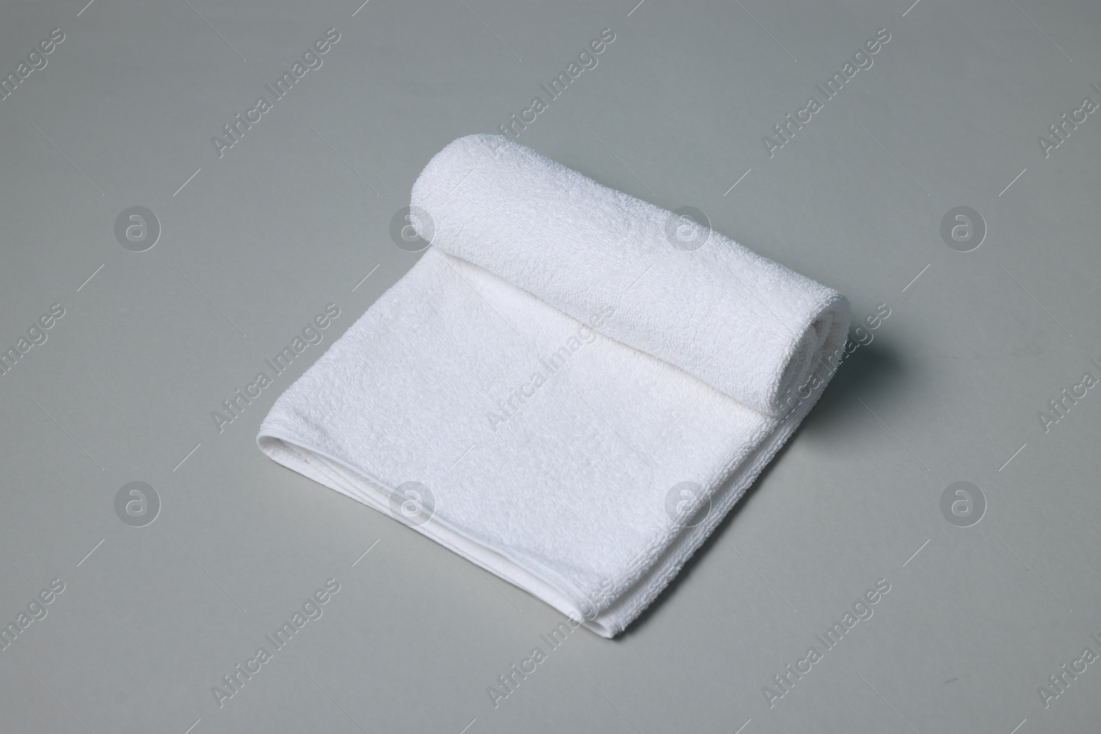 One clean terry towel on gray background Photo of One clean terry towel on gray background