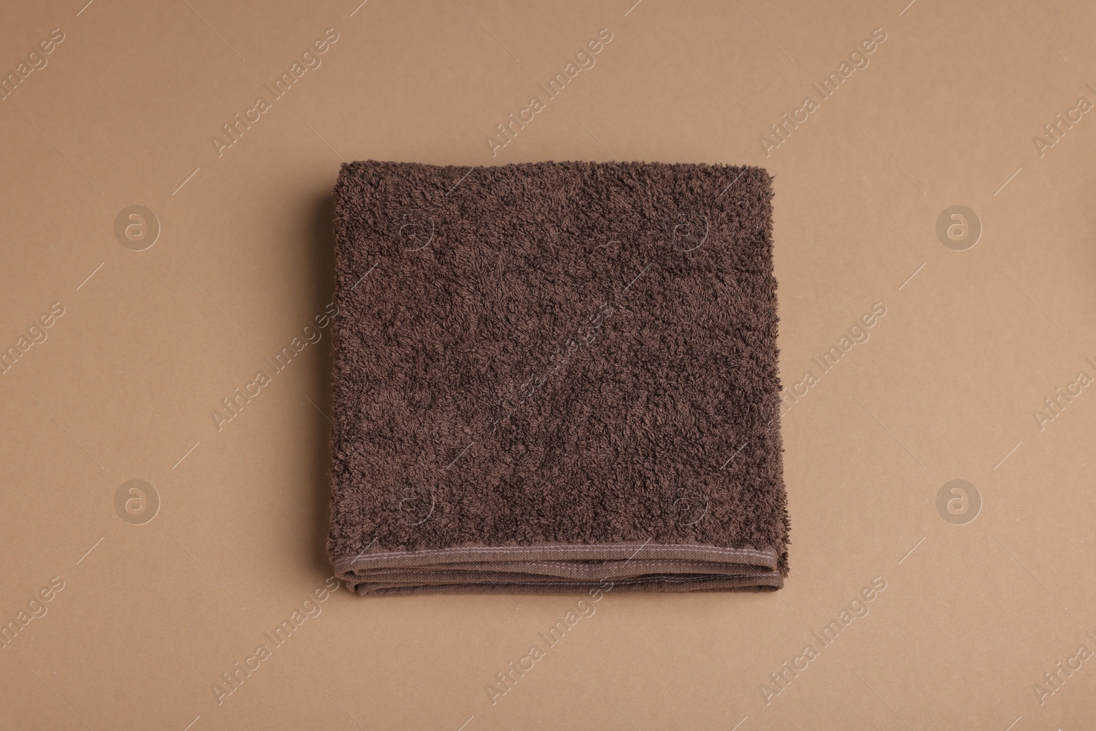 Clean towel on brown background, above view Photo of Clean towel on brown background, above view