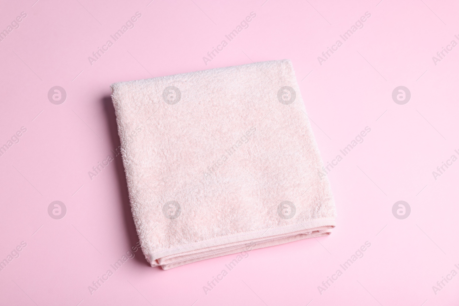 Clean towel on pink background, above view Photo of Clean towel on pink background, above view