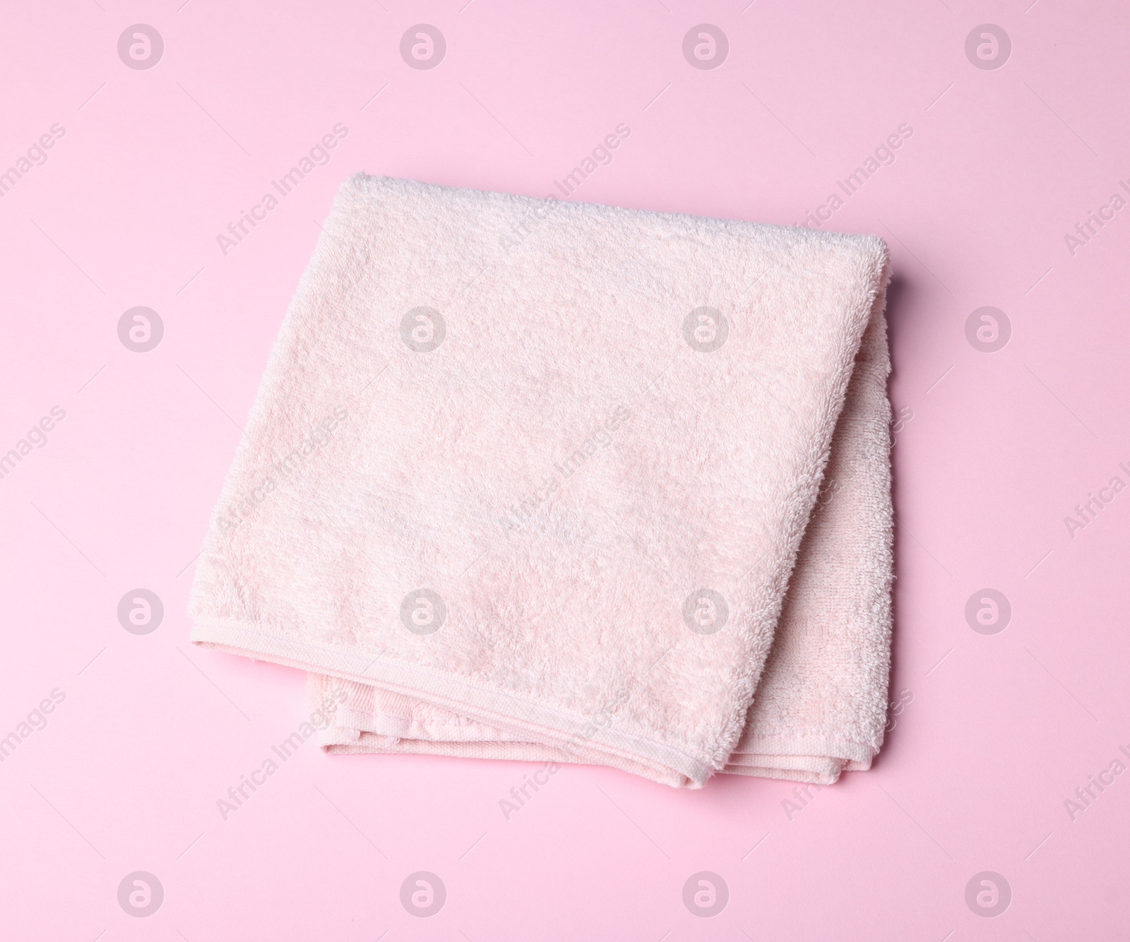 Clean towel on pink background, above view Photo of Clean towel on pink background, above view