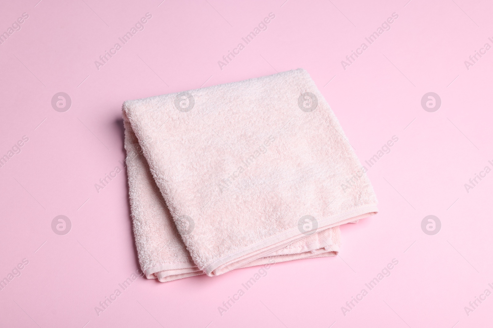 Clean towel on pink background, above view Photo of Clean towel on pink background, above view