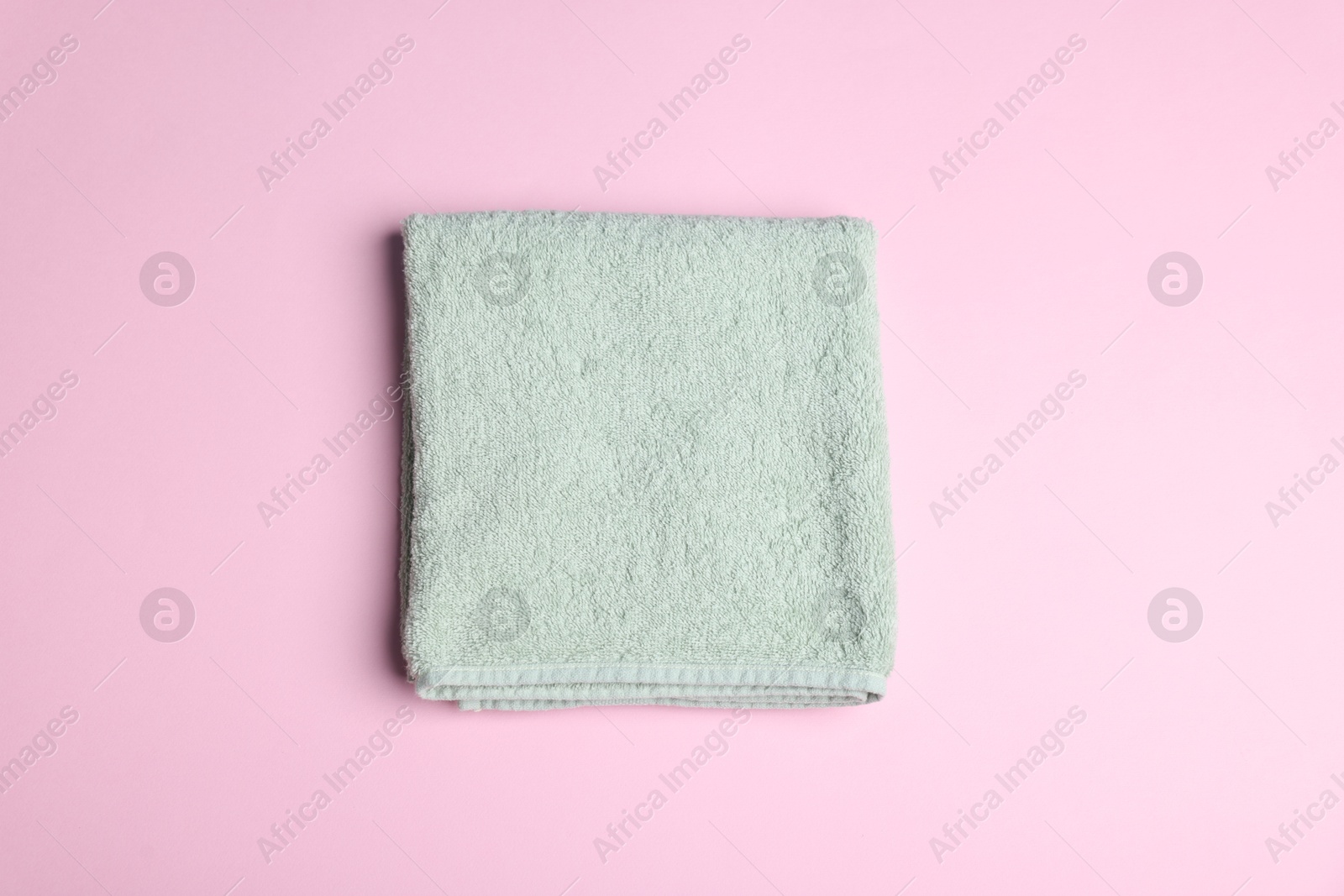 Clean towel on pink background, top view Photo of Clean towel on pink background, top view