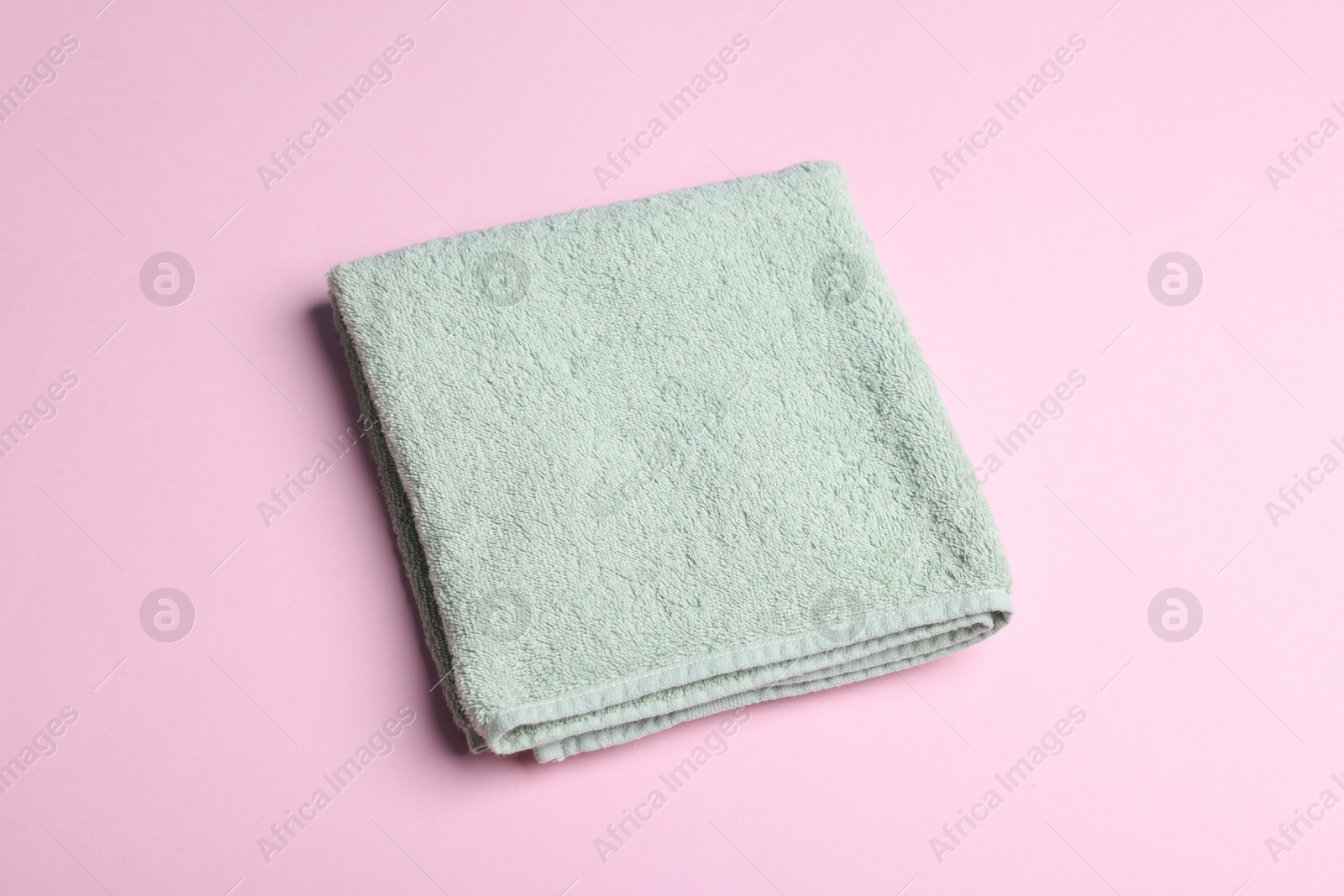 Clean towel on pink background, above view Photo of Clean towel on pink background, above view