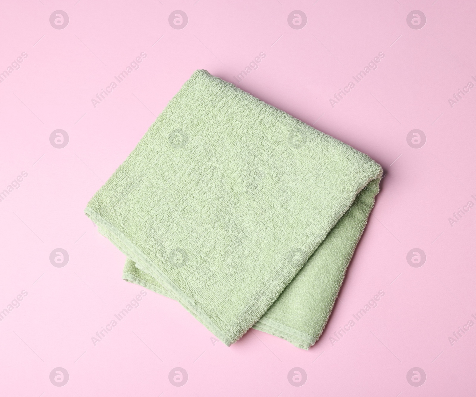 Clean towel on pink background, top view Photo of Clean towel on pink background, top view