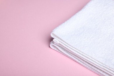 Photo of Clean towel on pink background, closeup. Space for text