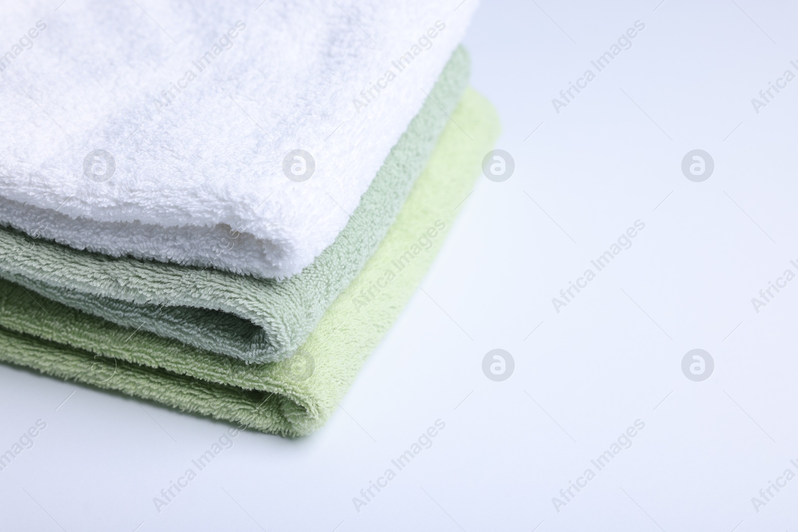 Stack of clean towels on white background, closeup. Space for text Photo of Stack of clean towels on white background, closeup. Space for text