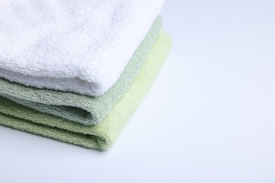 Photo of Stack of clean towels on white background, closeup. Space for text