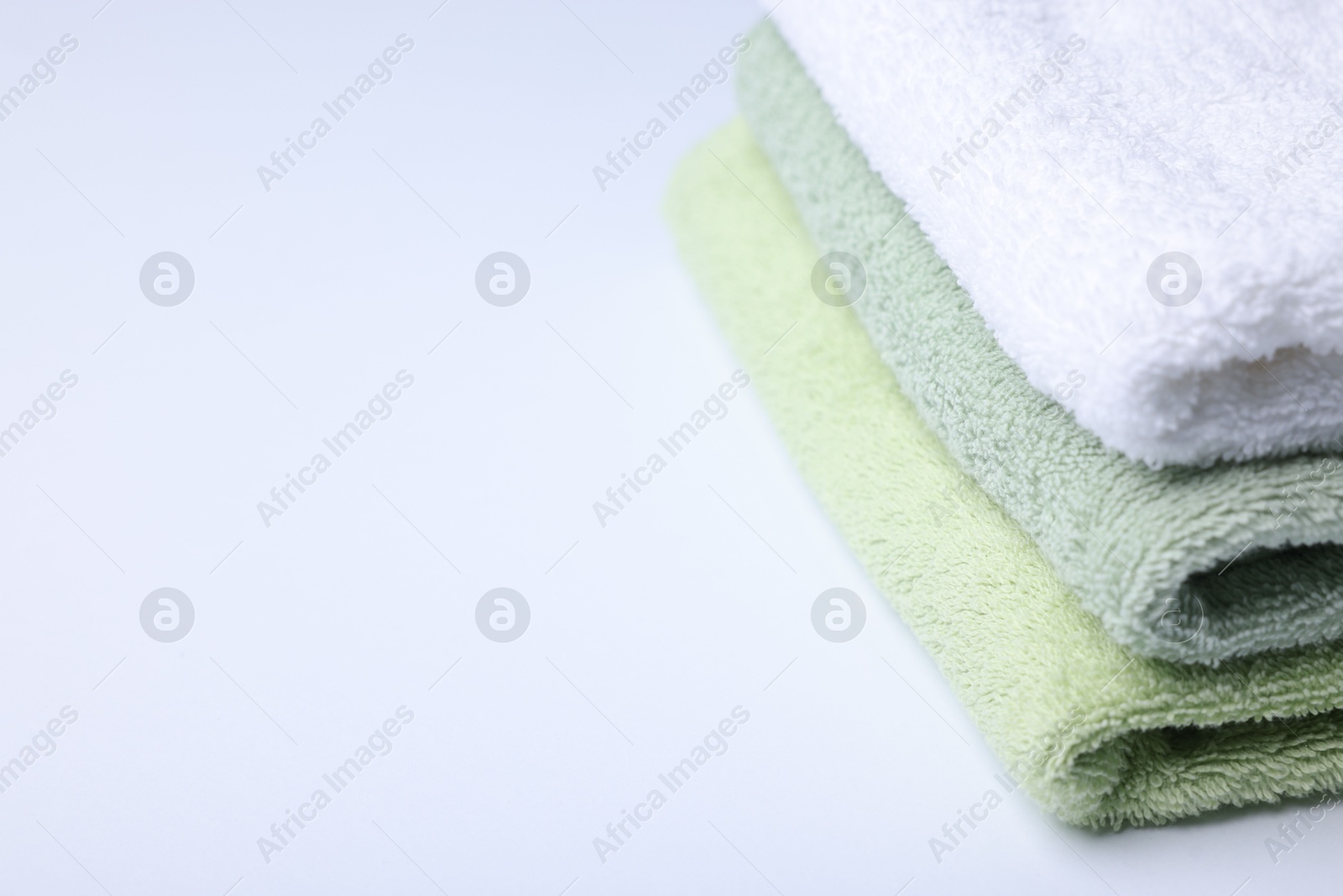 Stack of clean towels on white background, closeup. Space for text Photo of Stack of clean towels on white background, closeup. Space for text