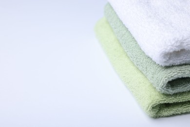 Photo of Stack of clean towels on white background, closeup. Space for text