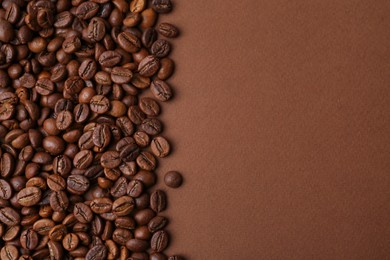 Photo of Aromatic coffee beans on brown background, top view. Space for text