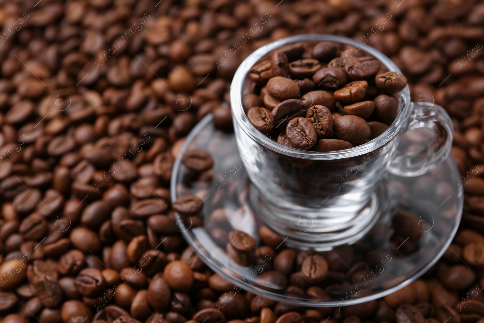Cup and saucer on coffee beans, closeup. Space for text Photo of Cup and saucer on coffee beans, closeup. Space for text
