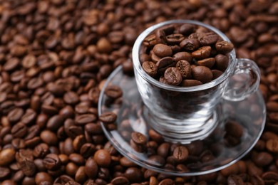 Photo of Cup and saucer on coffee beans, closeup. Space for text