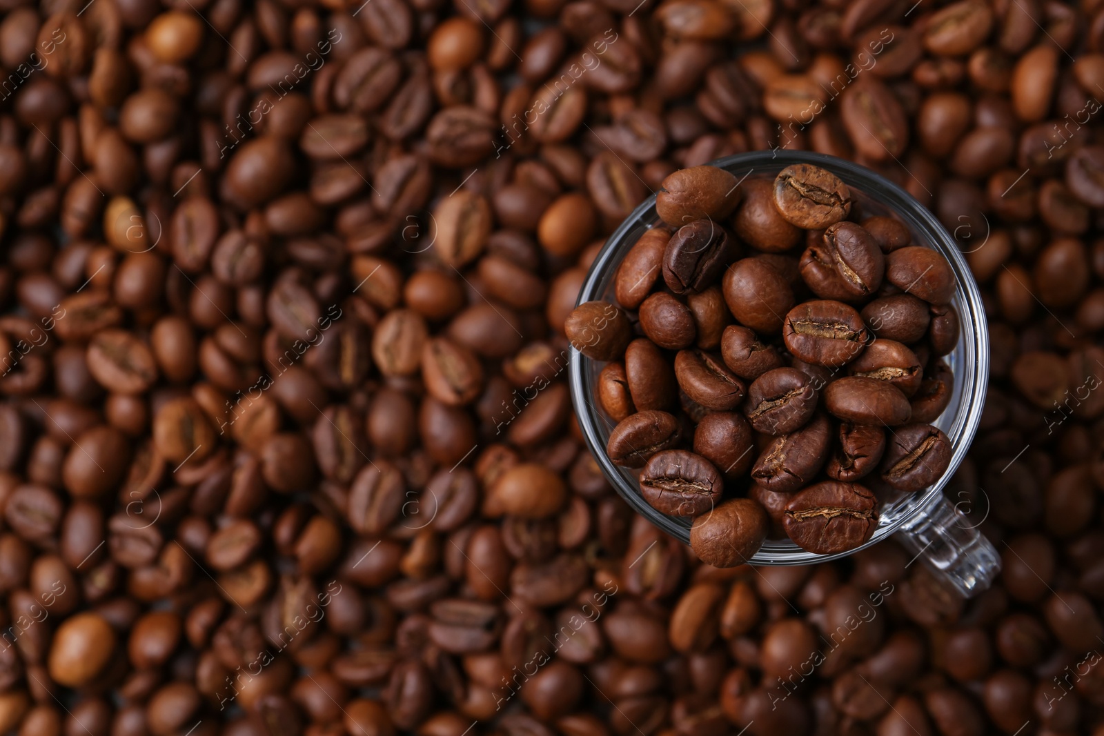 Aromatic coffee beans and glass cup on table, top view. Space for text Photo of Aromatic coffee beans and glass cup on table, top view. Space for text