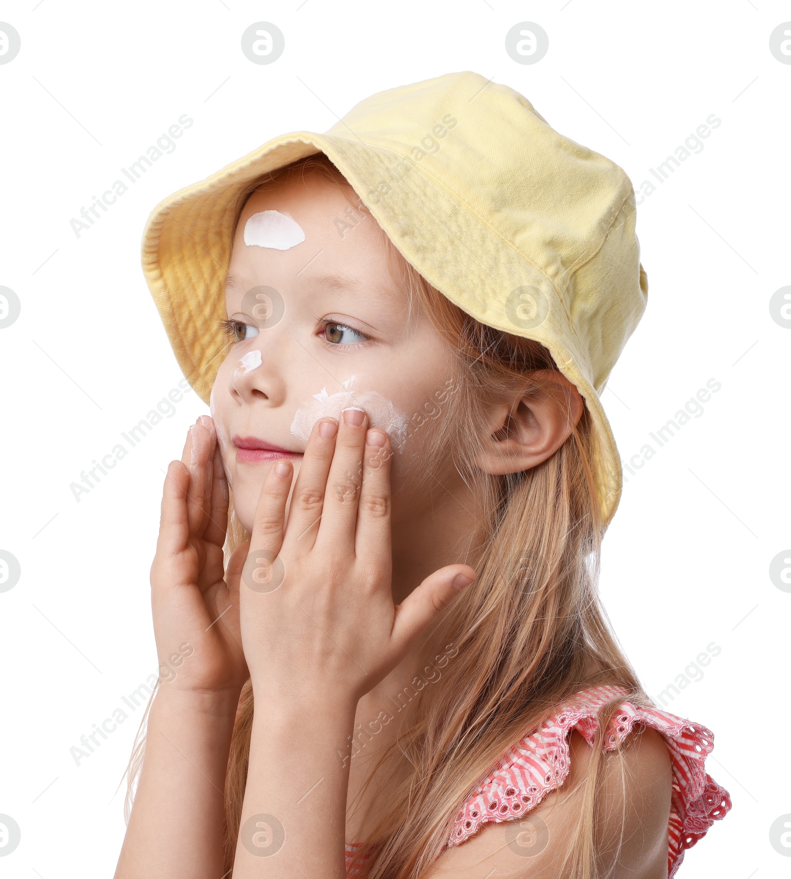 Photo of Cute little girl applying sun protection cream onto her skin against white background