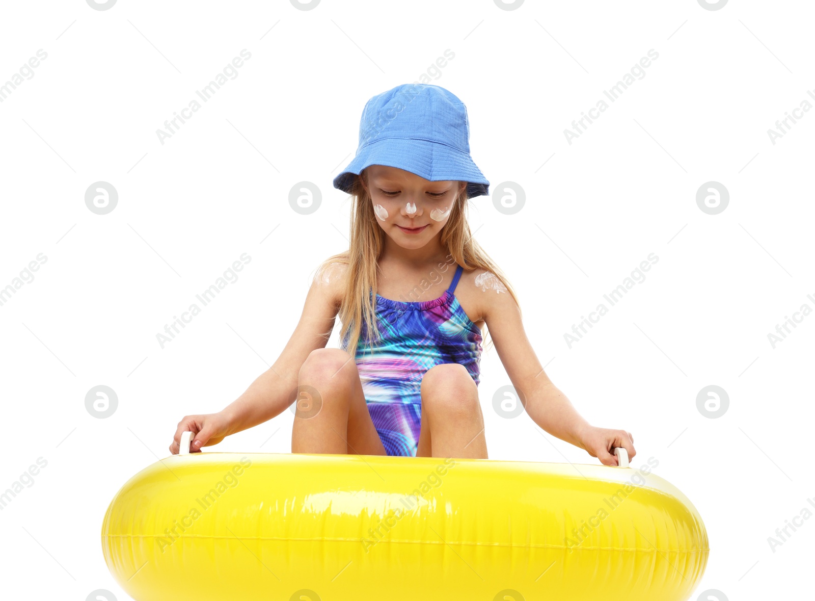 Photo of Cute little girl with sun protection cream on her skin and inflatable ring against white background