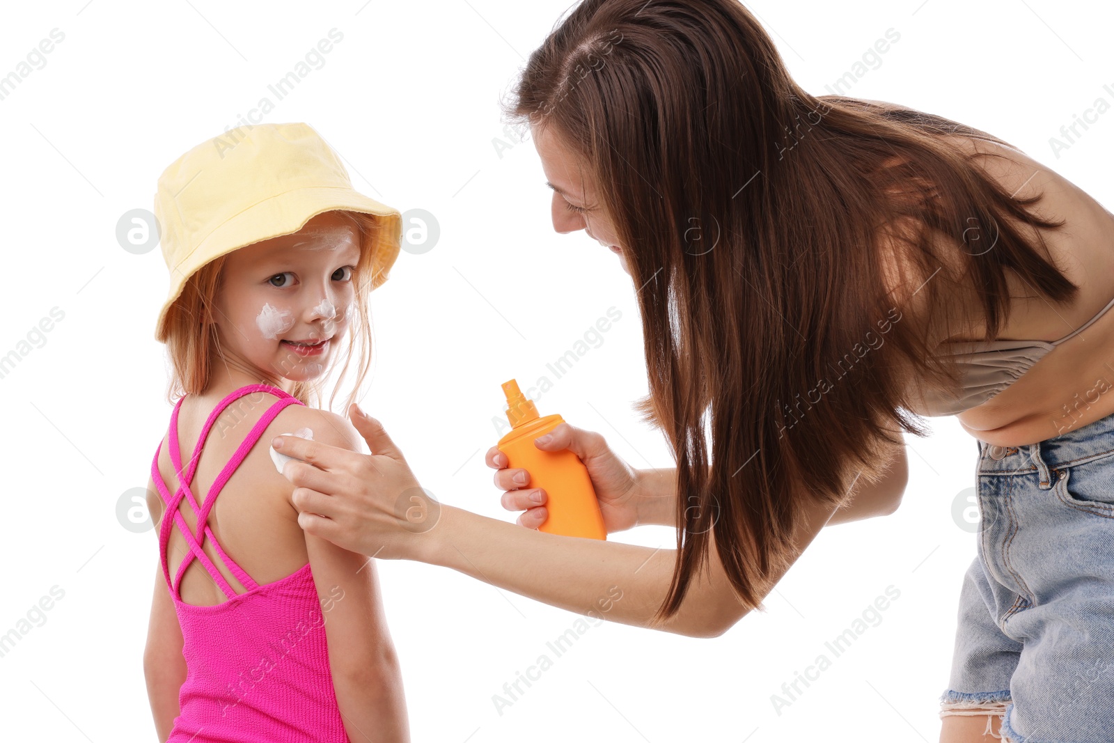 Photo of Mother applying sun protection product onto her daughter's skin on white background