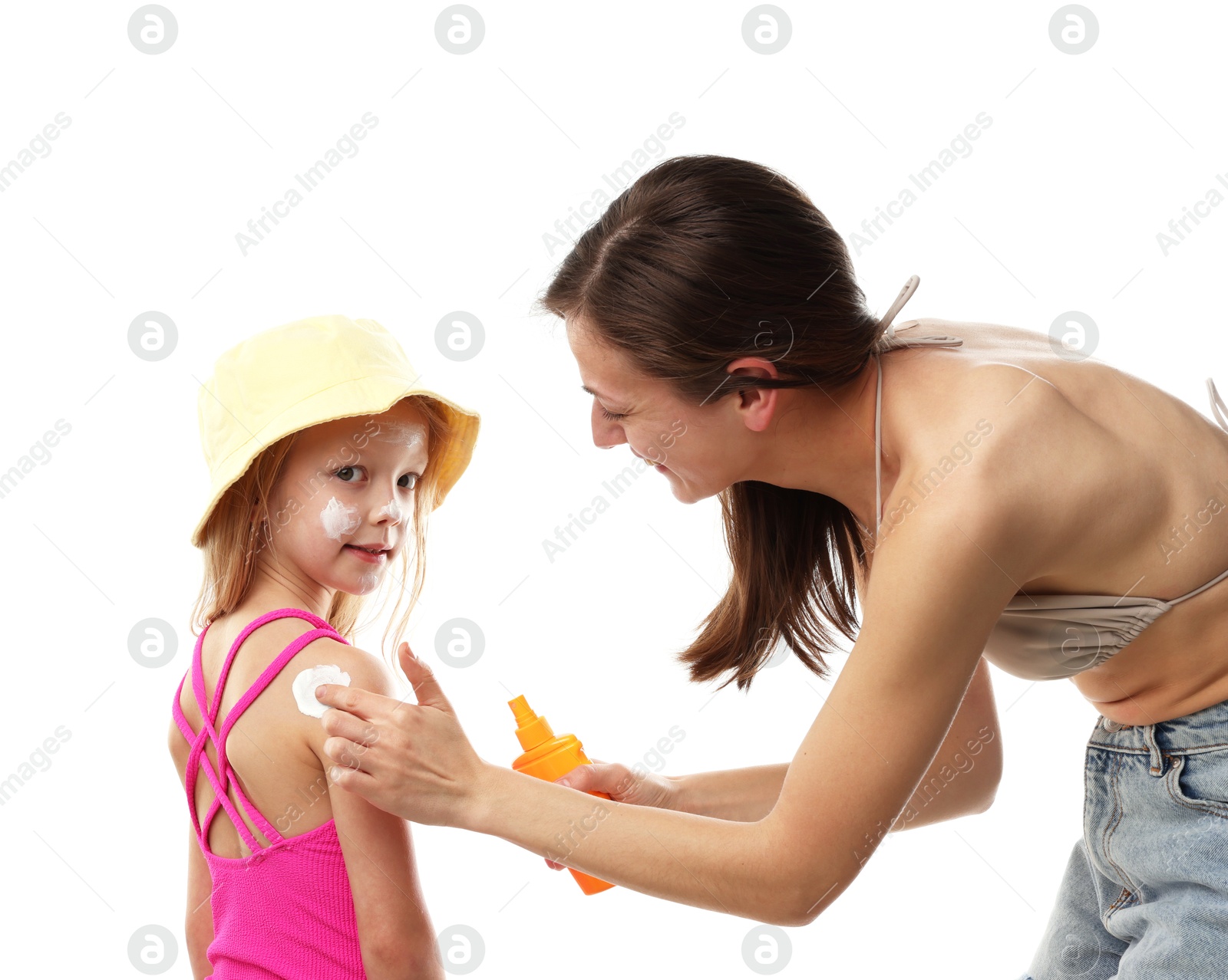 Photo of Mother applying sun protection product onto her daughter's skin on white background