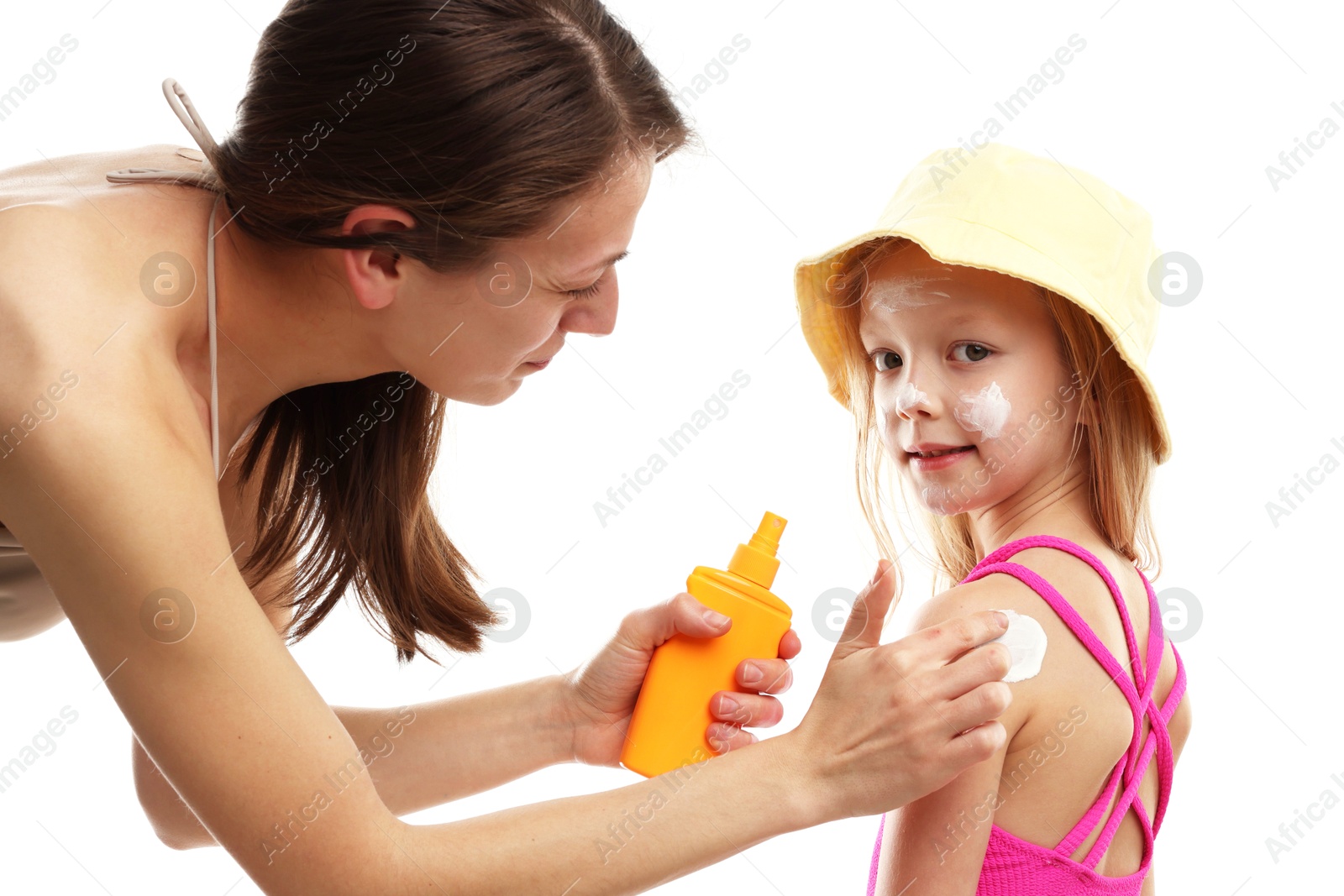 Photo of Mother applying sun protection product onto her daughter's skin on white background