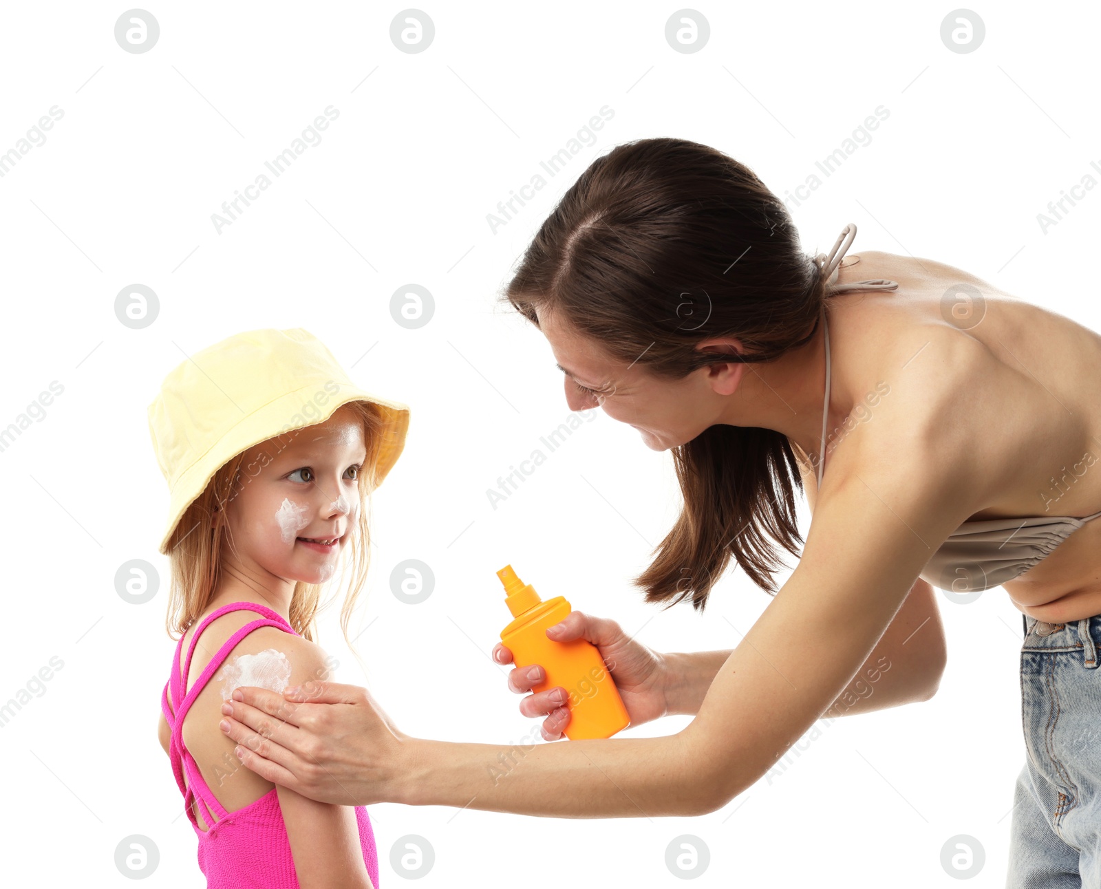 Mother applying sun protection product onto her daughter's skin on white background Photo of Mother applying sun protection product onto her daughter's skin on white background