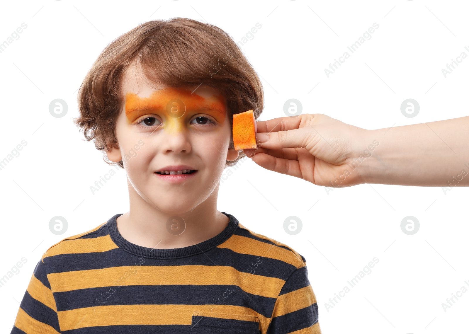 Photo of Animator drawing tiger on boy's face against white background, closeup