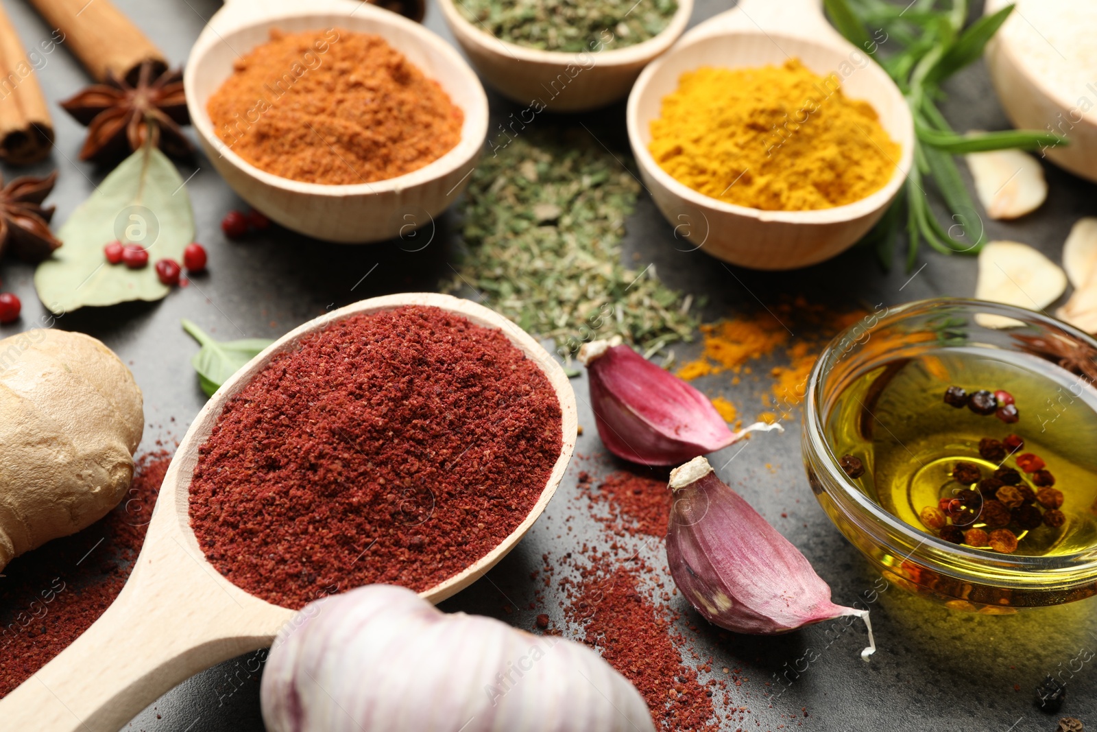 Different spices and oil on grey table, closeup Photo of Different spices and oil on grey table, closeup