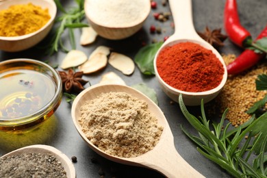 Photo of Different spices and oil on grey table, closeup