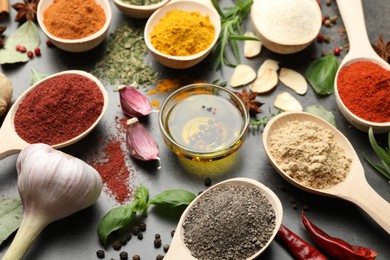 Photo of Different spices and oil on grey table, closeup