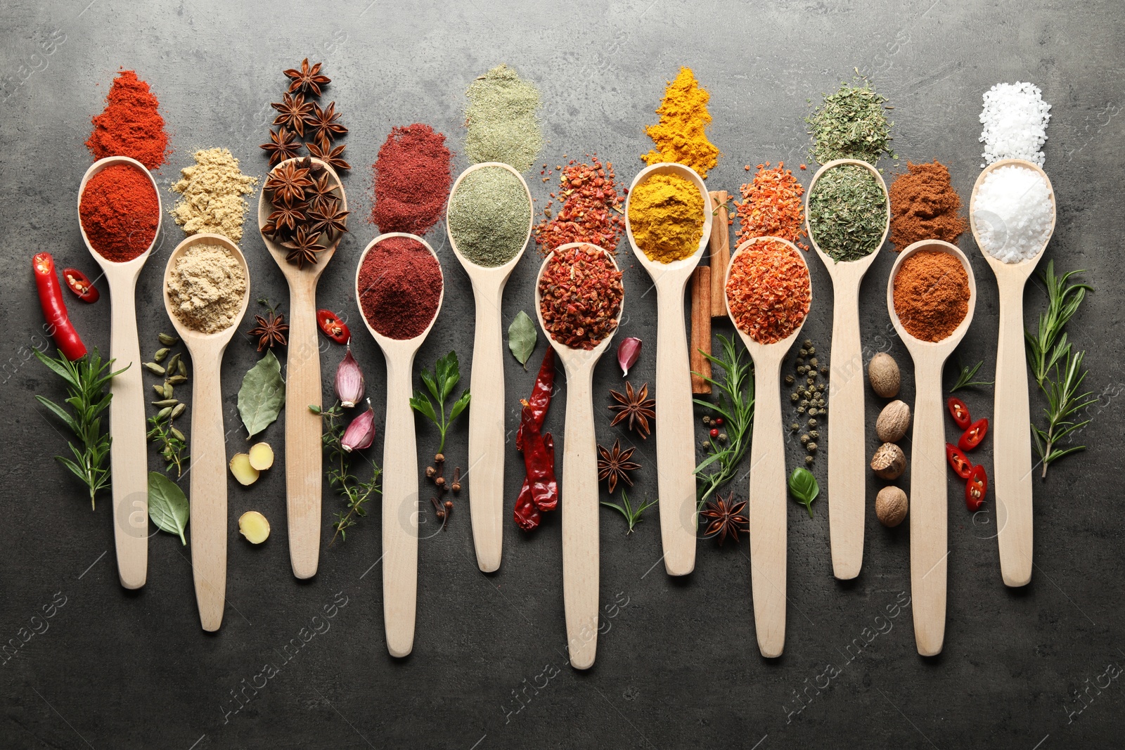 Many different spices in spoons on grey table, flat lay Photo of Many different spices in spoons on grey table, flat lay