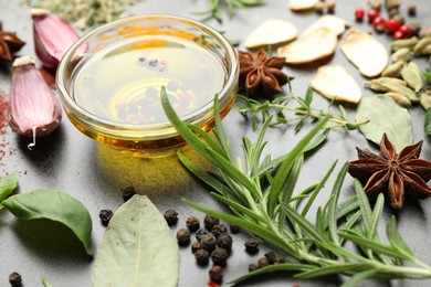 Photo of Different spices and oil on grey table, closeup