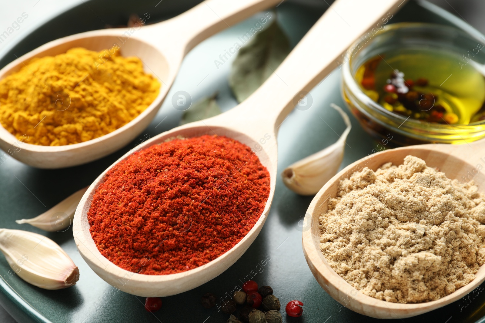 Many different spices in spoons on grey table, closeup Photo of Many different spices in spoons on grey table, closeup