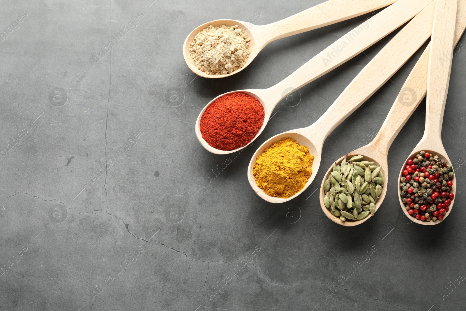 Many different spices in spoons on grey table, flat lay. Space for text Photo of Many different spices in spoons on grey table, flat lay. Space for text