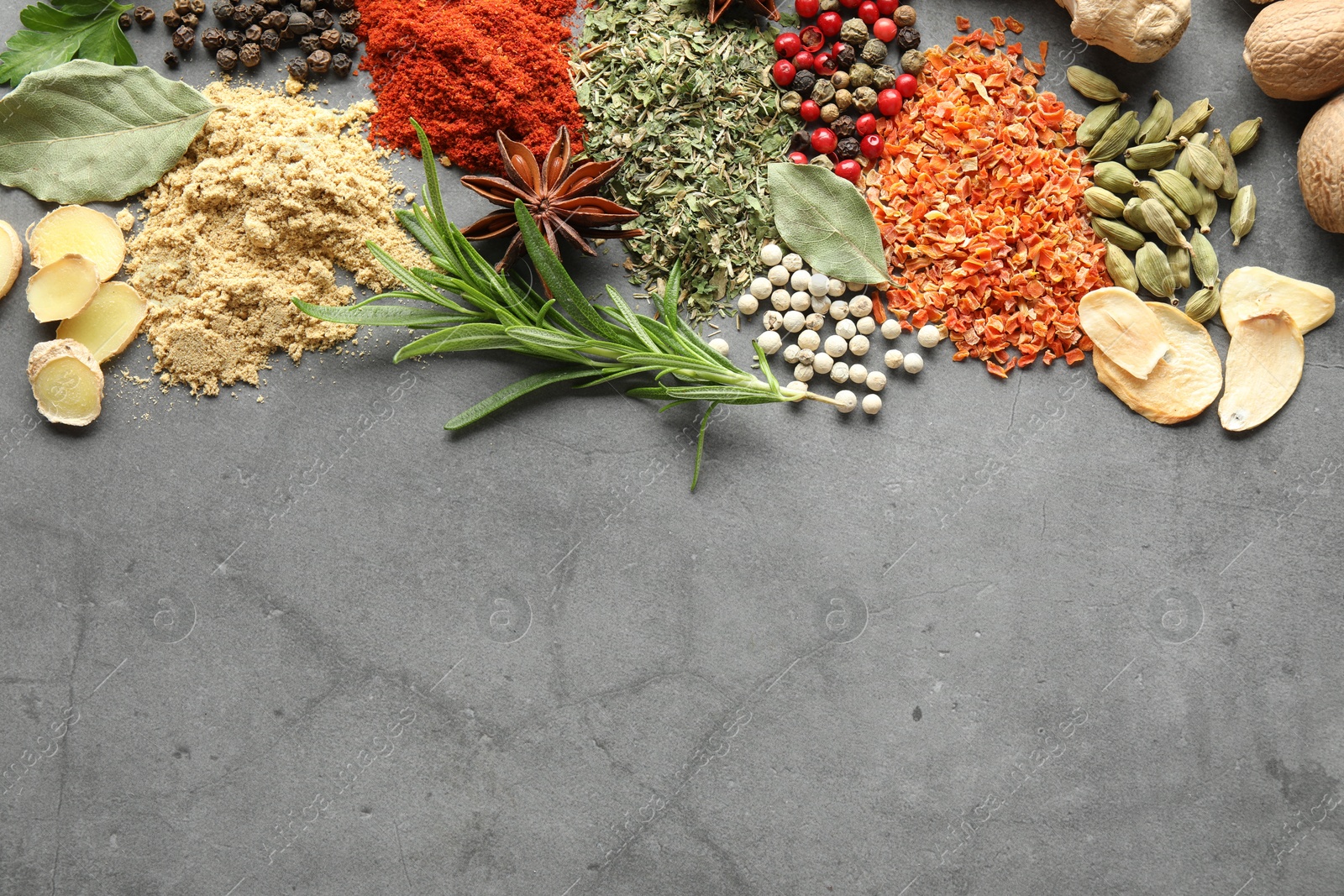 Different spices on grey table, flat lay. Space for text Photo of Different spices on grey table, flat lay. Space for text