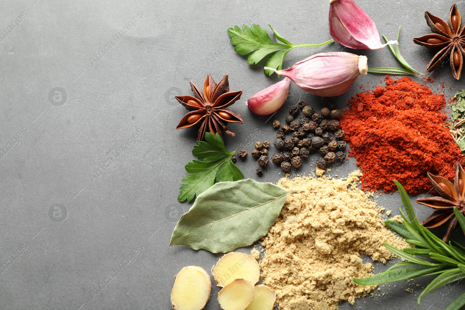 Different spices on grey table, flat lay. Space for text Photo of Different spices on grey table, flat lay. Space for text