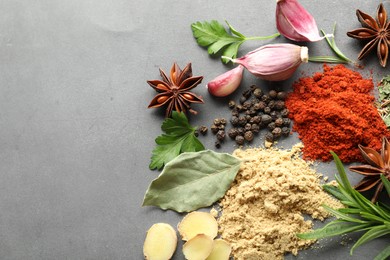 Photo of Different spices on grey table, flat lay. Space for text