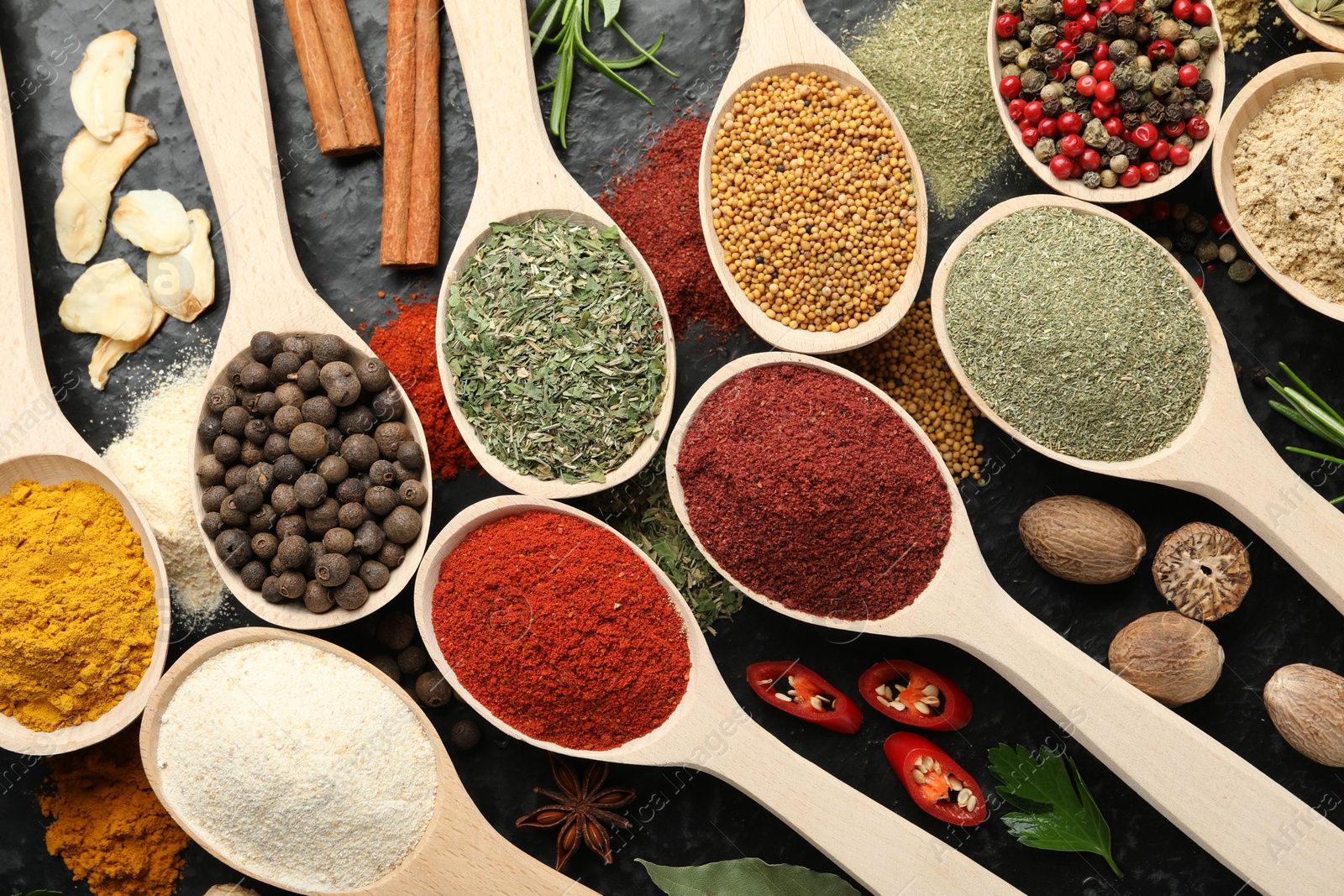 Many different spices in spoons on grey table, flat lay Photo of Many different spices in spoons on grey table, flat lay