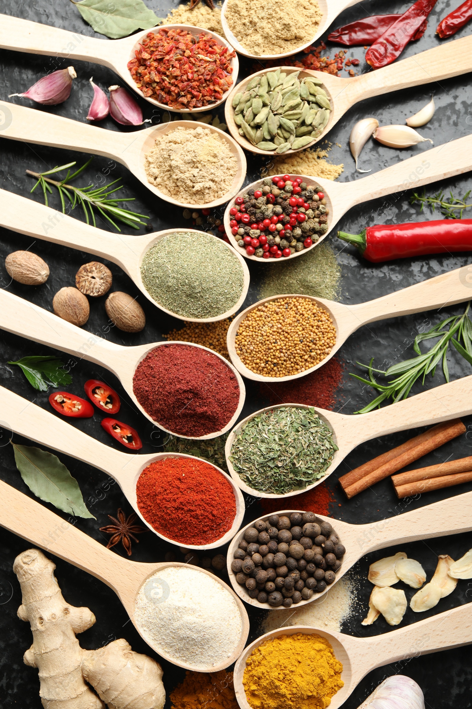 Many different spices in spoons on grey table, flat lay Photo of Many different spices in spoons on grey table, flat lay