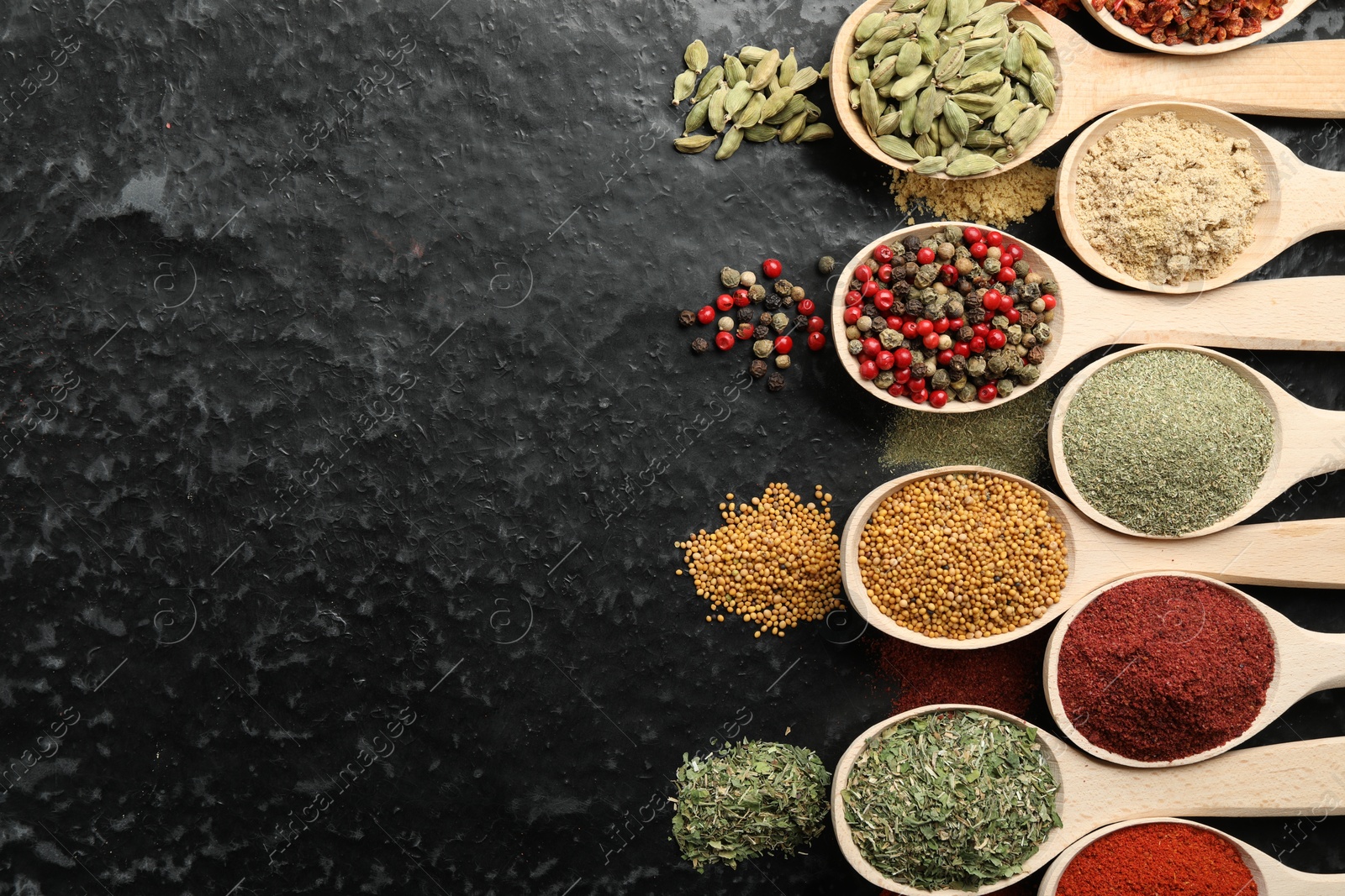 Many different spices in spoons on black table, flat lay. Space for text Photo of Many different spices in spoons on black table, flat lay. Space for text