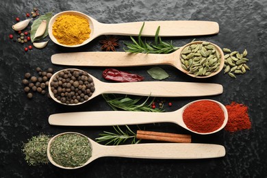 Photo of Many different spices in spoons on black table, flat lay