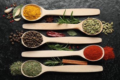 Photo of Many different spices in spoons on black table, flat lay