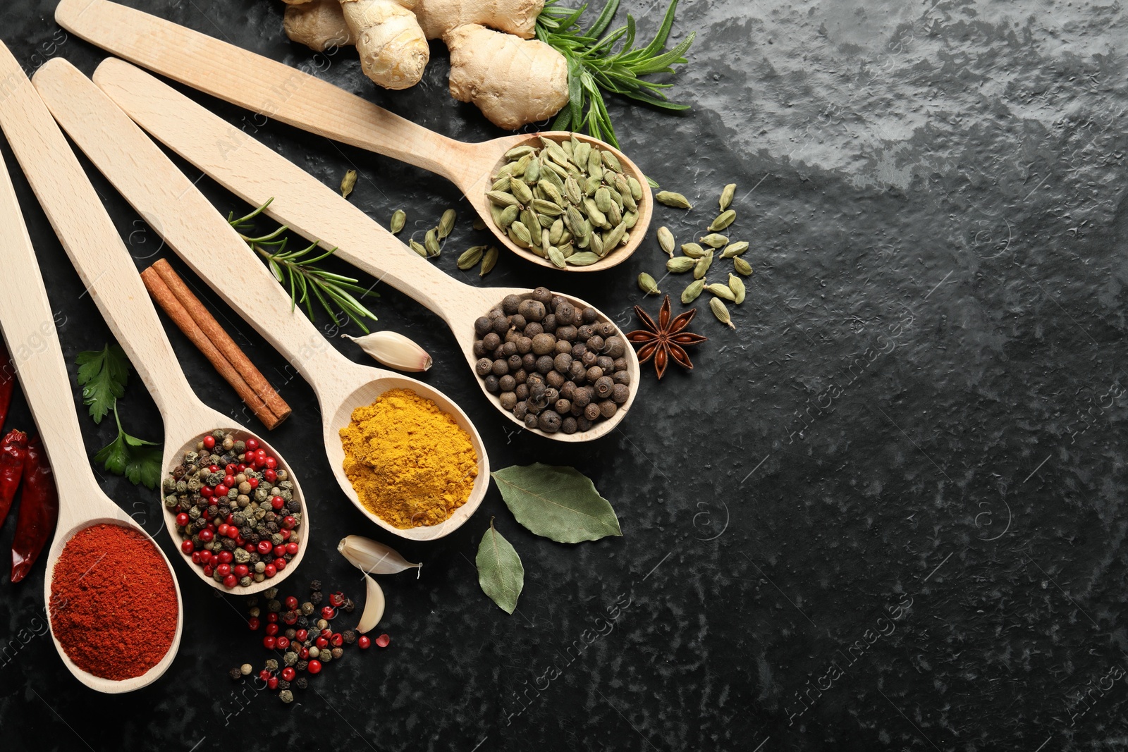 Many different spices in spoons on black table, flat lay. Space for text Photo of Many different spices in spoons on black table, flat lay. Space for text