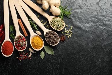 Photo of Many different spices in spoons on black table, flat lay. Space for text
