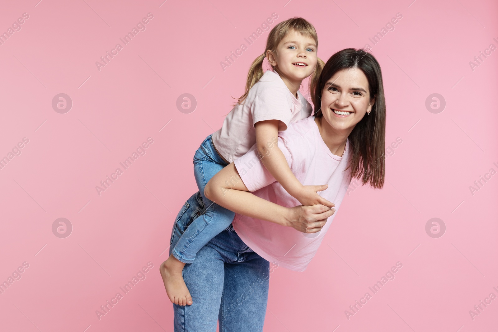 Photo of Happy mother and her cute daughter on pink background
