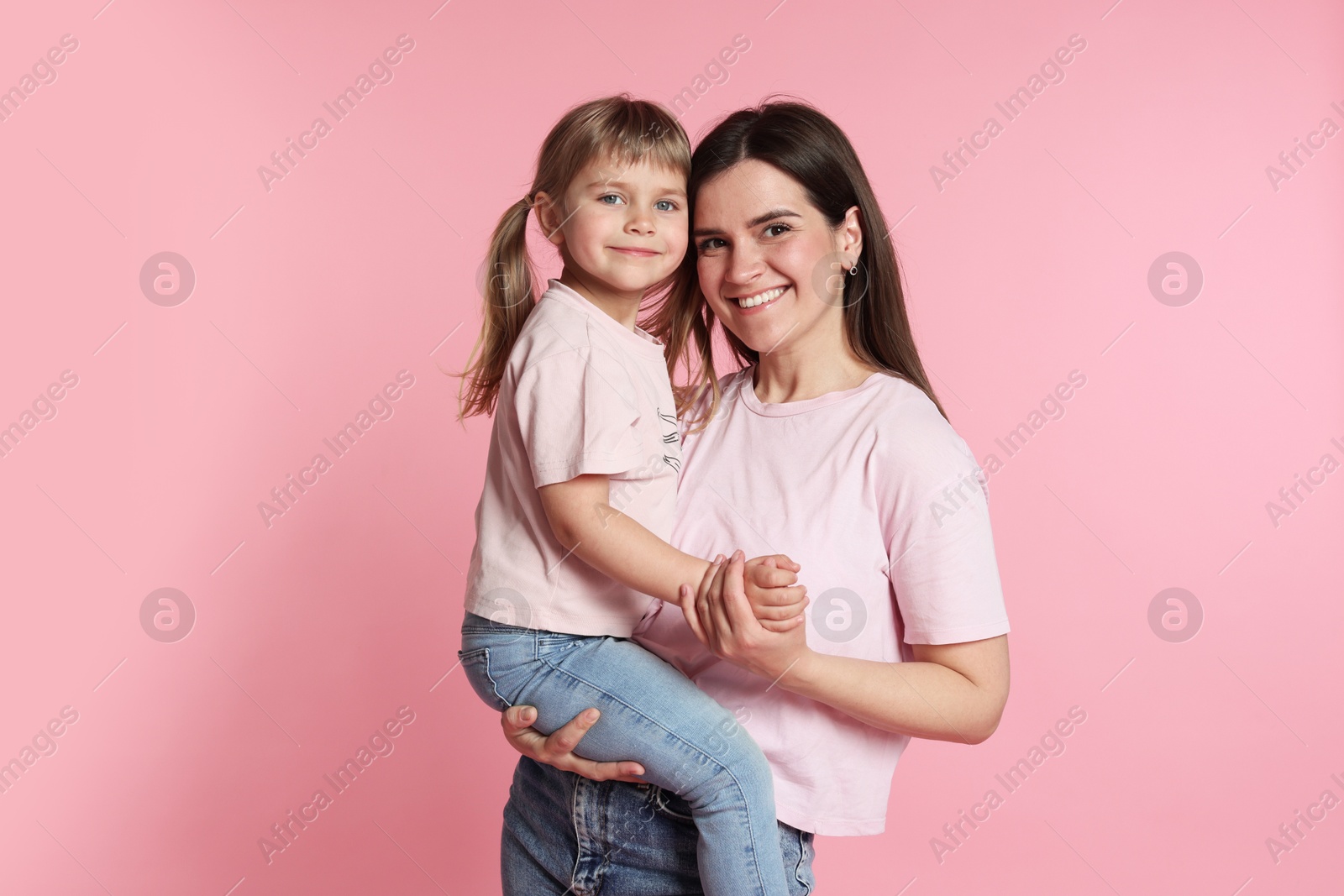 Photo of Happy mother and her cute daughter on pink background