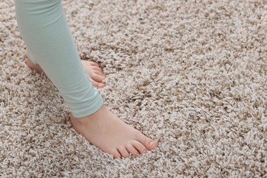 Photo of Girl on soft carpet at home, closeup. Space for text