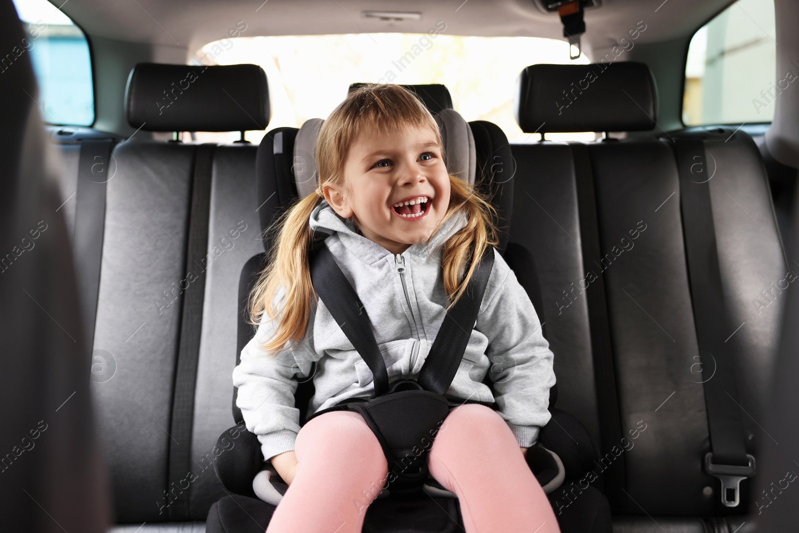 Little girl sitting in child safety seat inside car Photo of Little girl sitting in child safety seat inside car